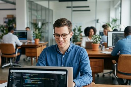 Jeune homme professionnel en train de coder dans un bureau moderne