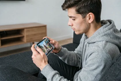 Homme jouant sur une PS Portal en cloud gaming dans un salon sans console PS5 visible